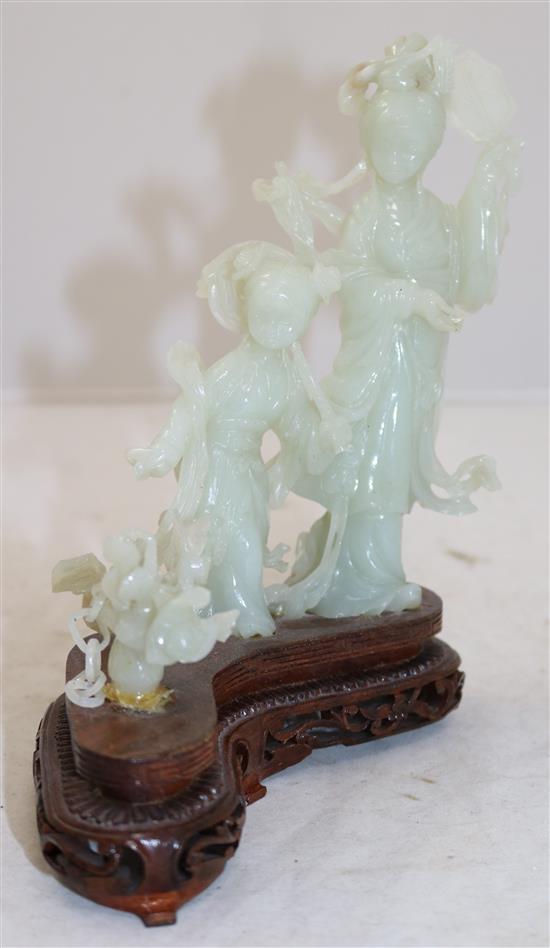 A Chinese pale celadon jade group of a lady and a girl with flowing robes, a basket beside them, 20th century, total height 19cm